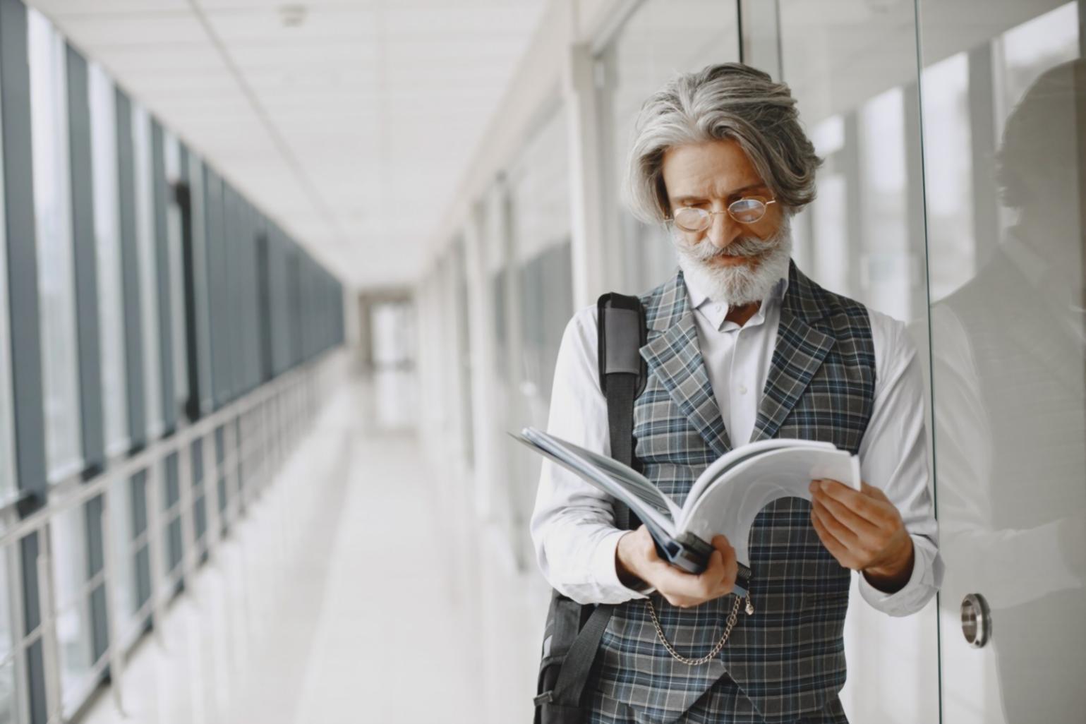 Financial analyst reviewing business documents and charts during initial assessment meeting